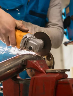 Technician worker cutting metal with many sharp sparks. Using equipments to cat iron